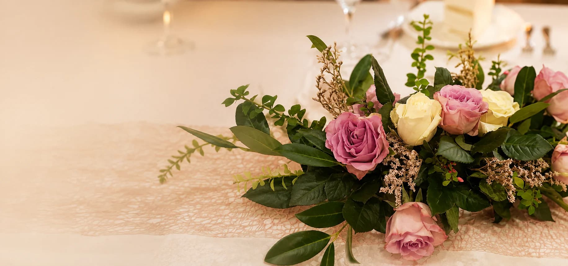 Rosenarrangement auf einer hell und festlich gedeckten Tafel